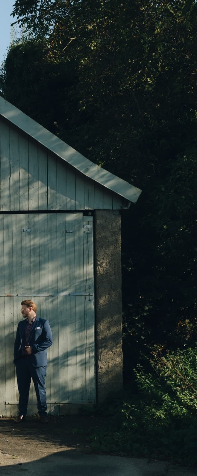 Georg im blauen Anzug vor der Scheune